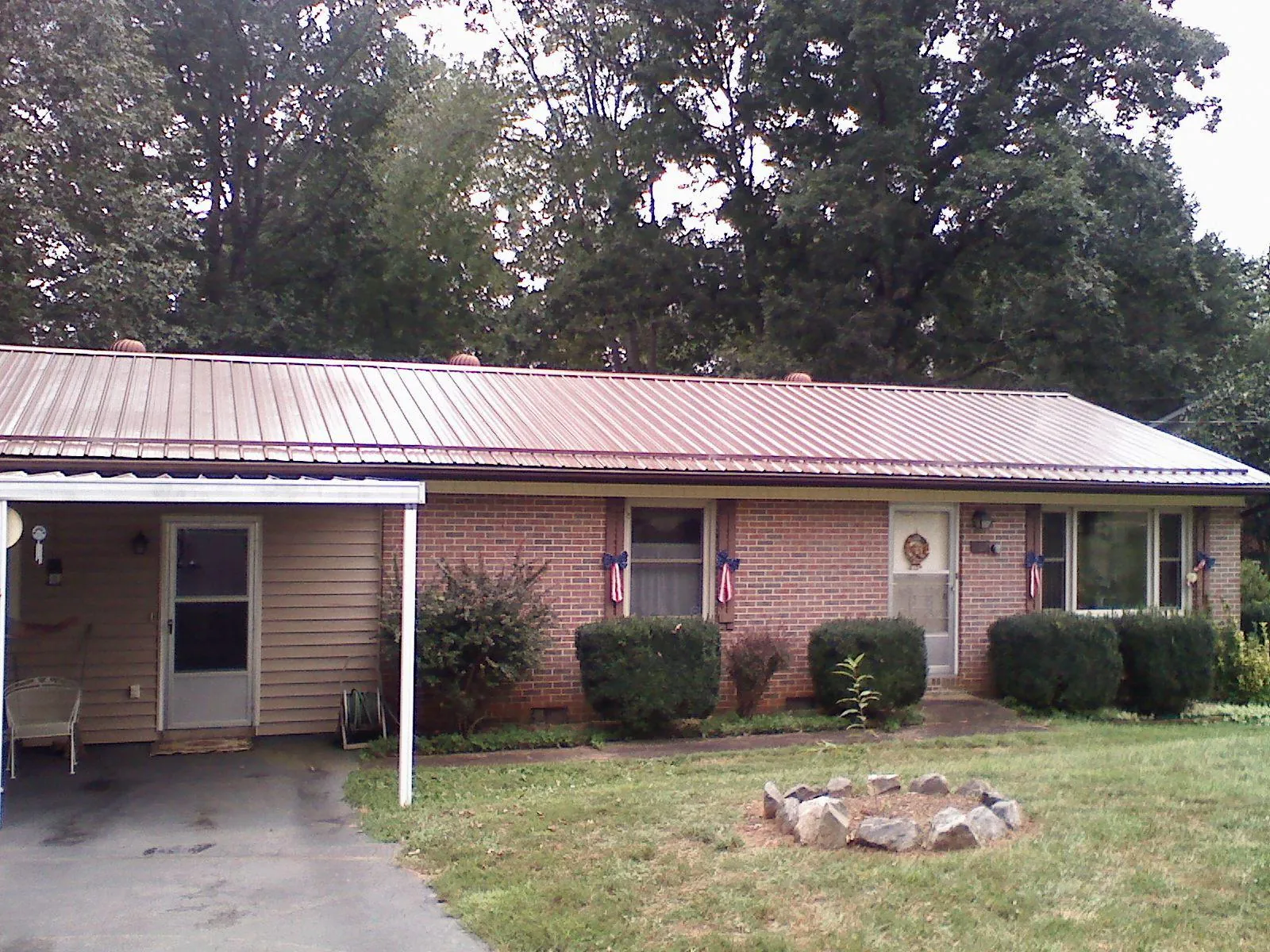 Bronze metal roof and carport on a brick ranch home — Roof Repair work by our crew in Dibble
